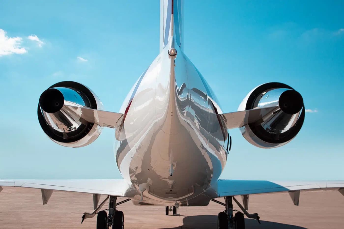 Rear view of a private jet on the tarmac against a blue sky