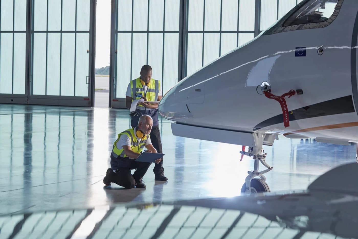 Ground crew inspecting a private jet in a hangar