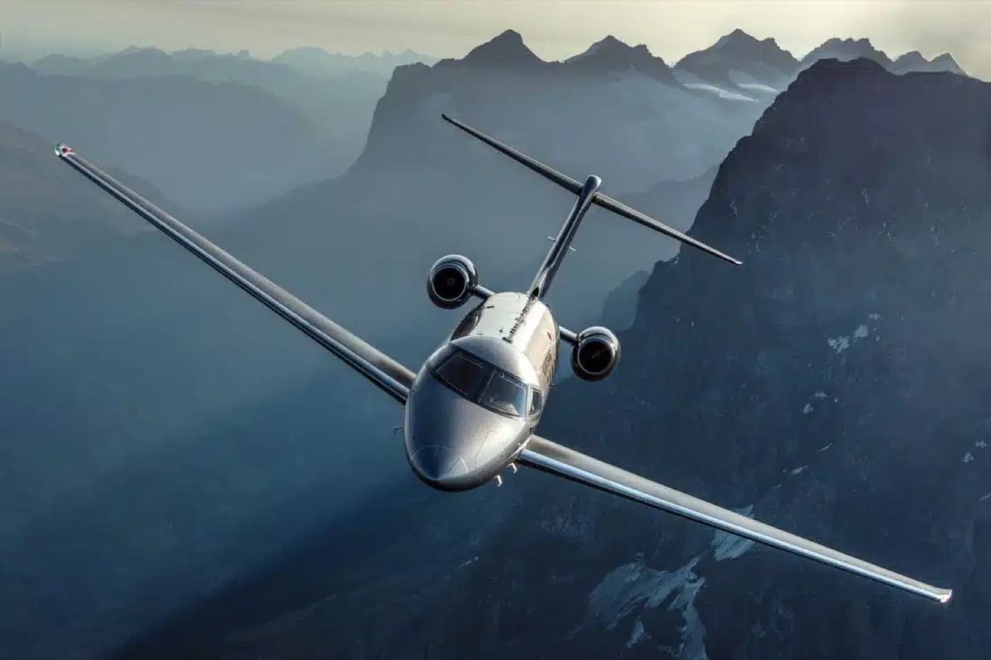 A private jet in flight over a mountain range