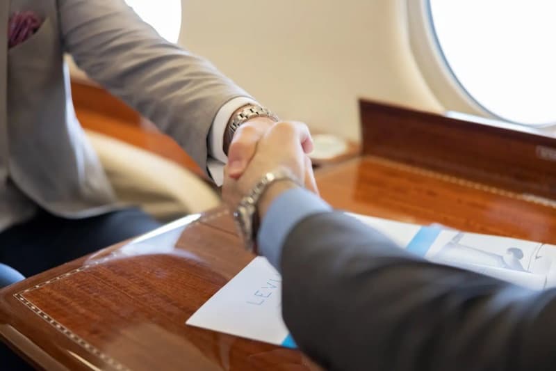 A Leviate broker shaking hands over aircraft paperwork