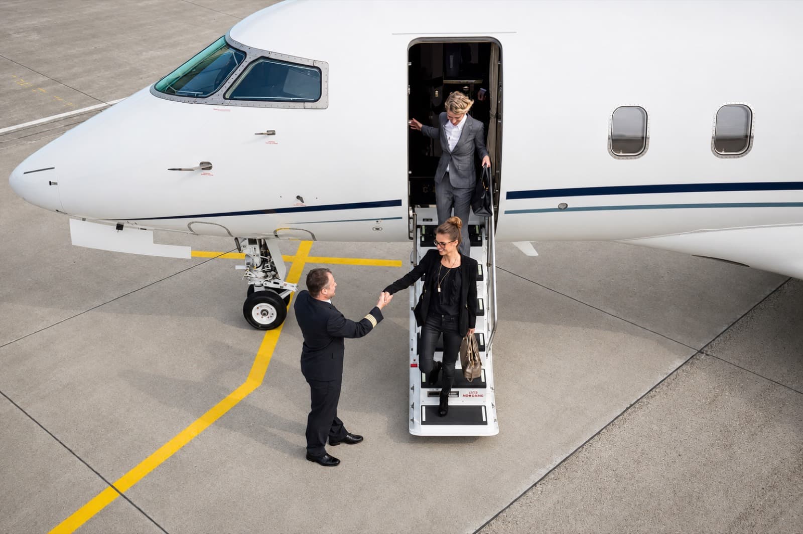 A Leviate captain greeting passengers as they step off a private jet