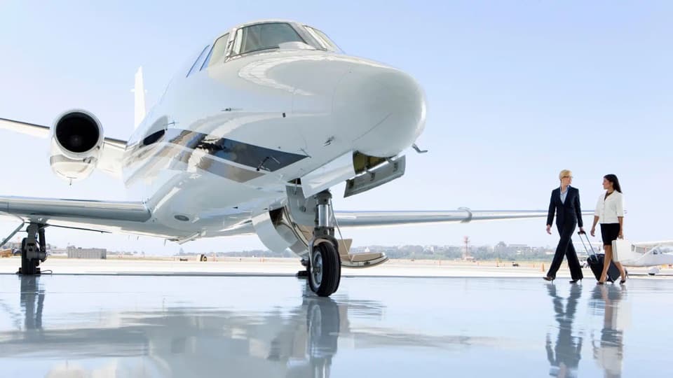 Travelers walking toward a private jet on the tarmac