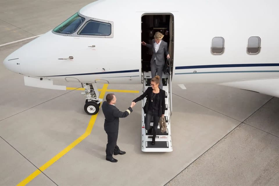 A Leviate team member greeting clients as they board a private jet