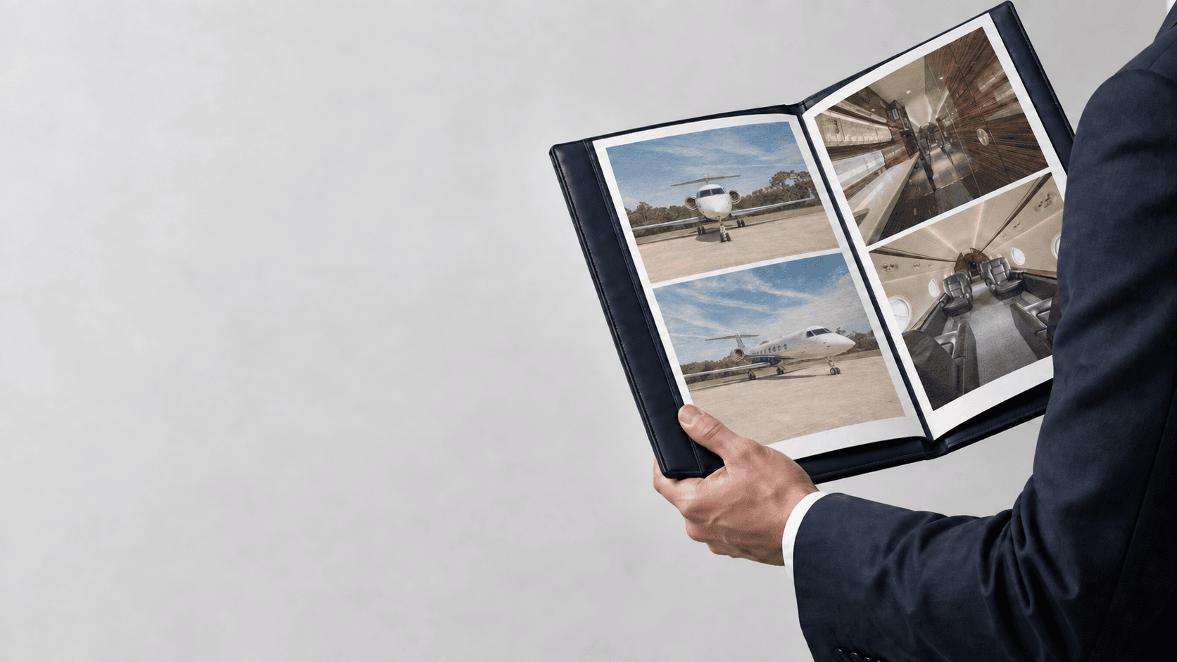 Aircraft advisor holding an open portfolio of G550 exterior and interior photographs
