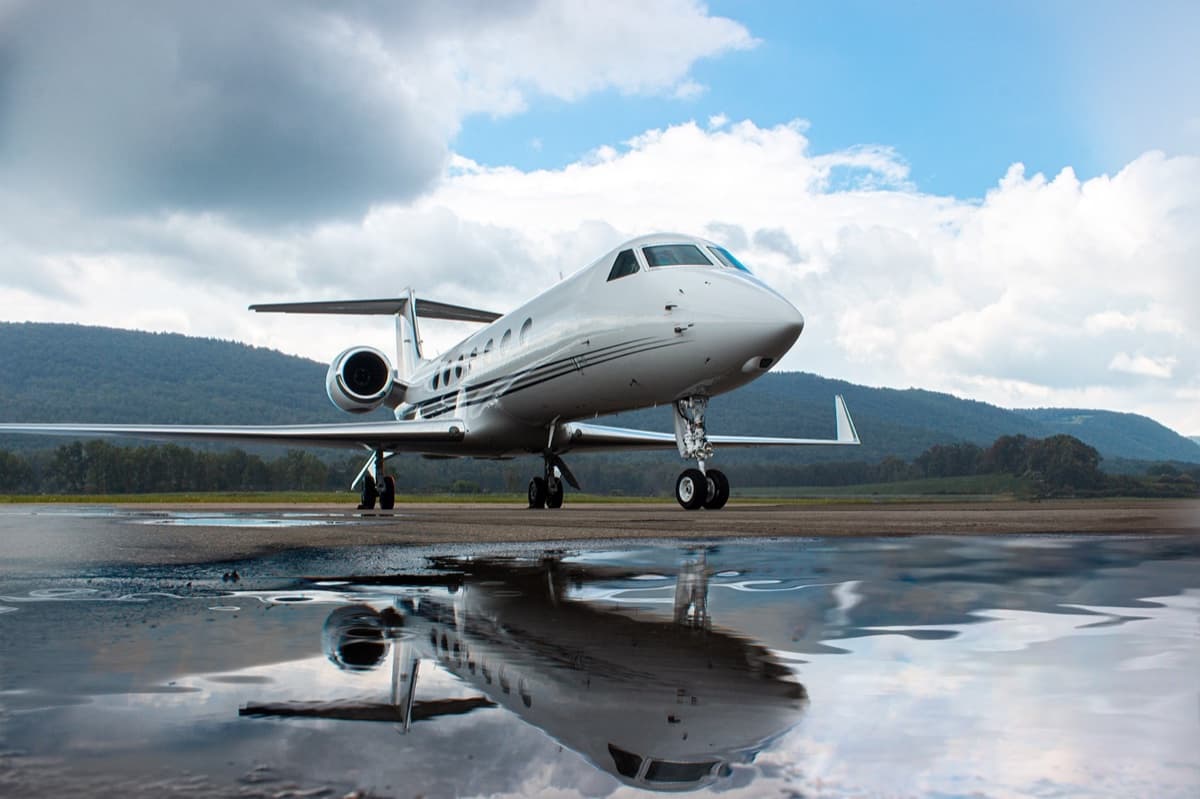Gulfstream private jet on the ramp with a runway reflection