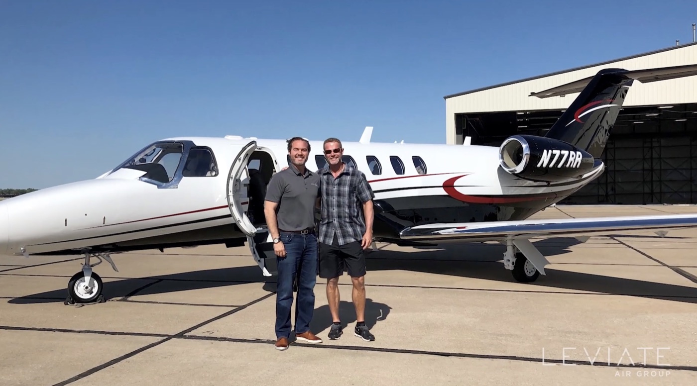 Randall Reed with the Leviate team beside a private jet